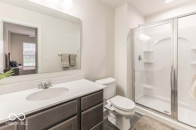 bathroom with hardwood / wood-style floors, vanity, toilet, and an enclosed shower