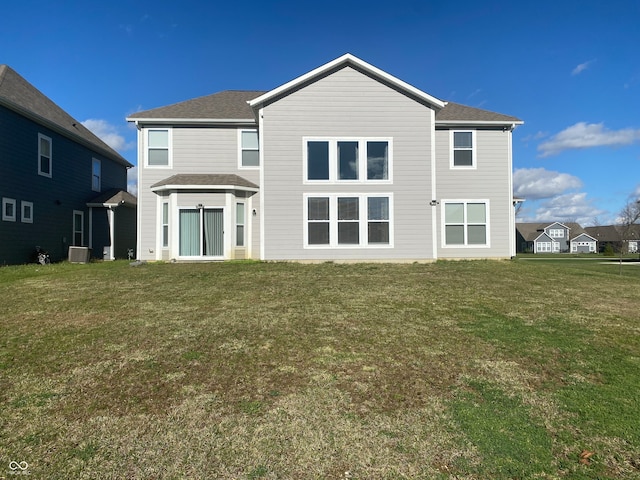 rear view of house featuring a yard and central AC unit