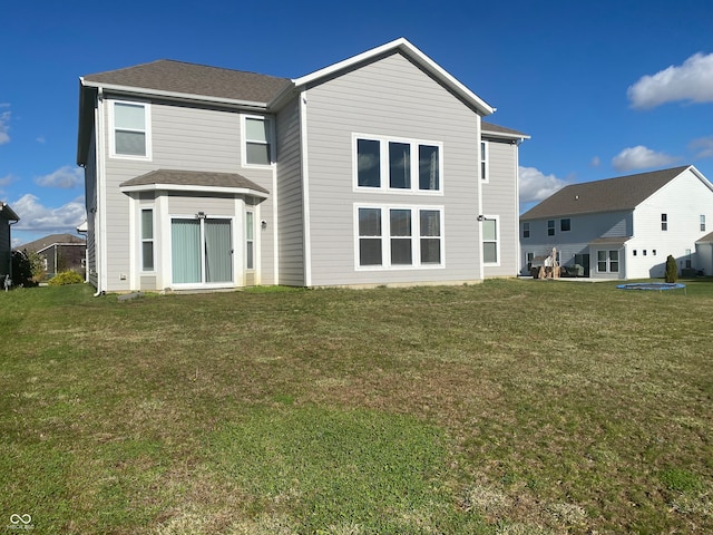 rear view of property featuring a lawn