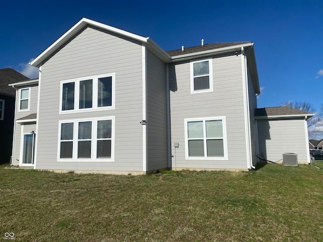 rear view of property with a yard and central AC unit