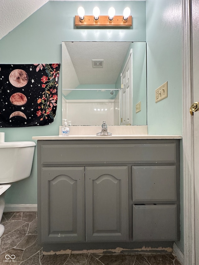 bathroom featuring a textured ceiling, a shower, tile patterned flooring, toilet, and lofted ceiling