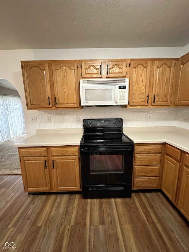 kitchen featuring decorative backsplash, dark hardwood / wood-style flooring, and black / electric stove