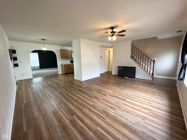 unfurnished living room with ceiling fan, wood-type flooring, and a textured ceiling