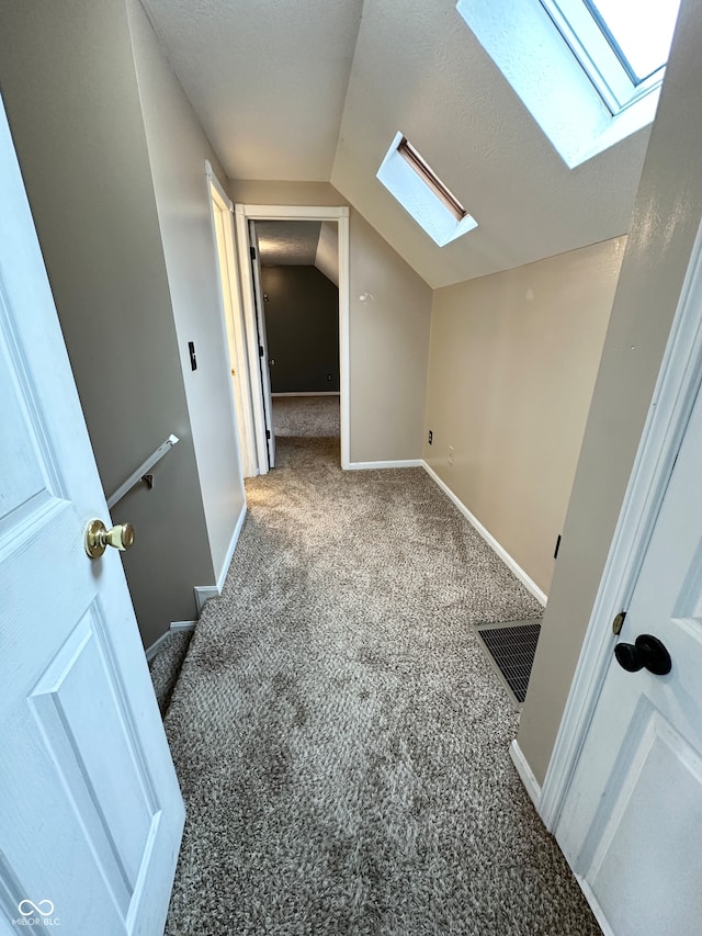 bonus room with carpet and vaulted ceiling with skylight