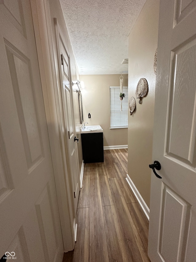 bathroom with vanity, wood-type flooring, and a textured ceiling