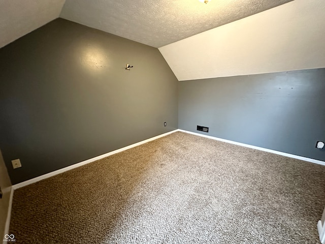 bonus room featuring a textured ceiling, carpet flooring, and vaulted ceiling