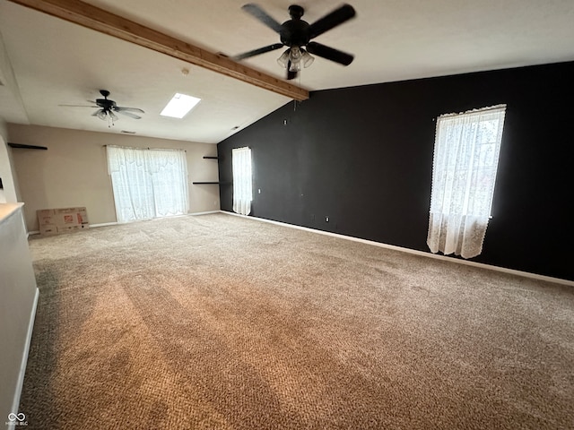 unfurnished room featuring plenty of natural light, ceiling fan, carpet floors, and lofted ceiling with skylight