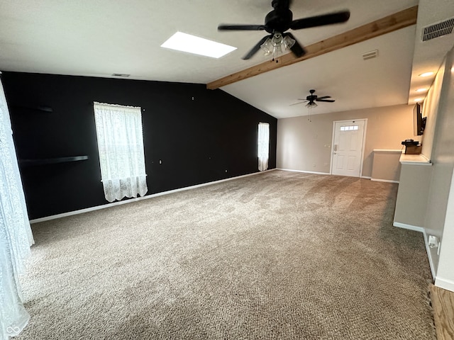 interior space featuring ceiling fan, lofted ceiling with skylight, and carpet floors