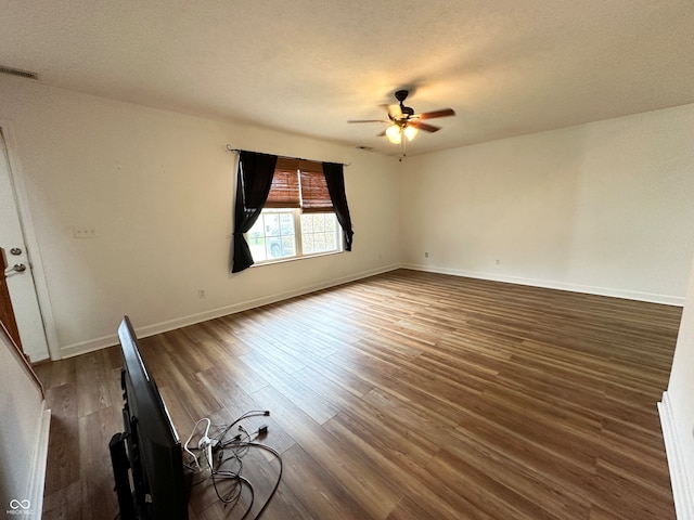 unfurnished room featuring a textured ceiling, dark hardwood / wood-style floors, and ceiling fan