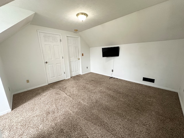 bonus room with carpet flooring, a textured ceiling, and vaulted ceiling