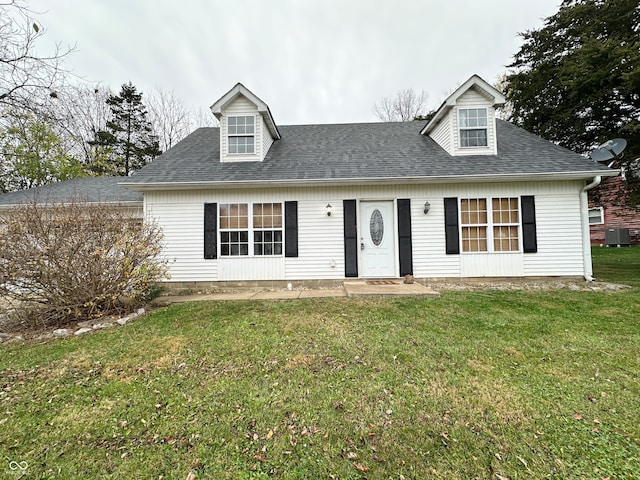 new england style home with central air condition unit and a front yard