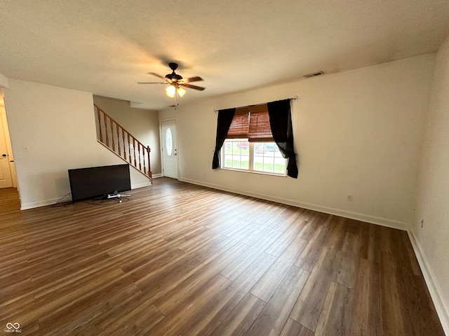 interior space featuring ceiling fan, dark hardwood / wood-style flooring, and a textured ceiling