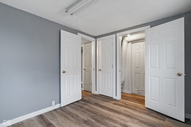 unfurnished bedroom with wood-type flooring and a textured ceiling