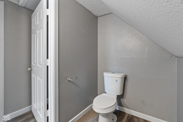 bathroom featuring wood-type flooring, a textured ceiling, and toilet