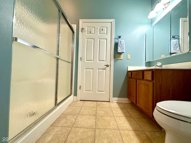 bathroom with tile patterned floors, toilet, vanity, and walk in shower