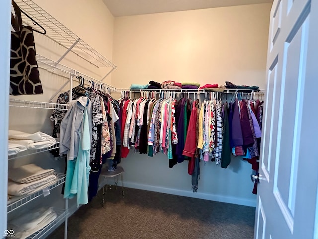 walk in closet featuring dark colored carpet