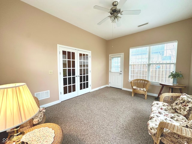 living area featuring ceiling fan, french doors, and dark colored carpet