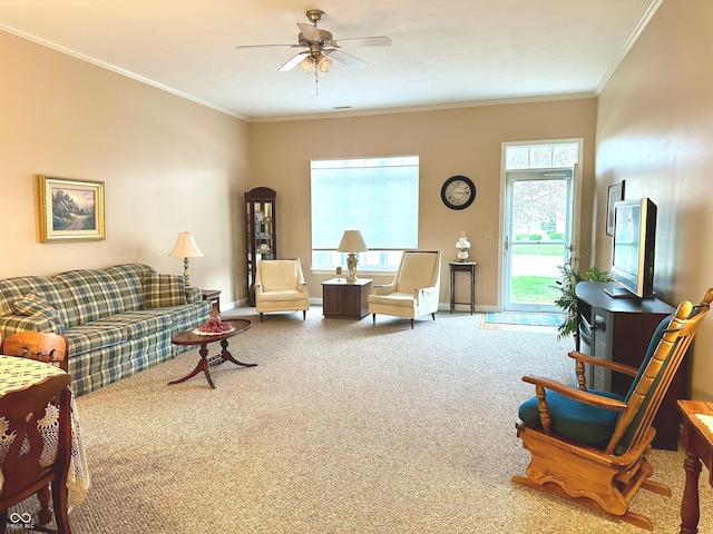 living room featuring carpet flooring, ceiling fan, crown molding, and a wealth of natural light