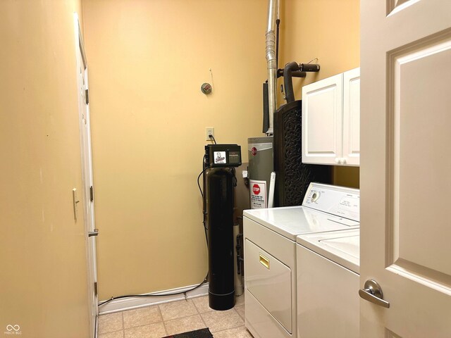 laundry room featuring separate washer and dryer, water heater, light tile patterned floors, and cabinets