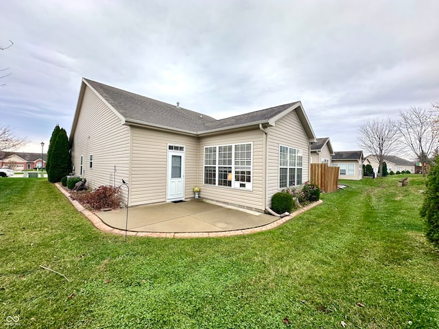 back of property with a patio area and a yard