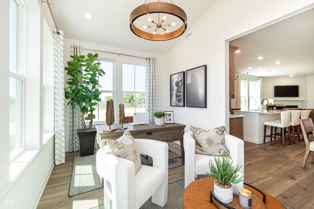 living room featuring plenty of natural light, a chandelier, and light hardwood / wood-style floors