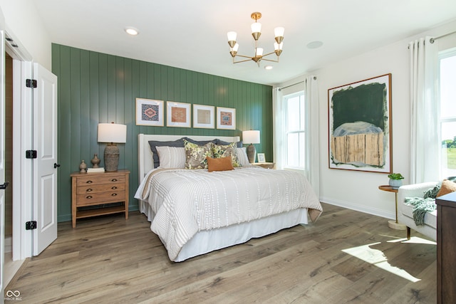 bedroom with hardwood / wood-style floors and a notable chandelier