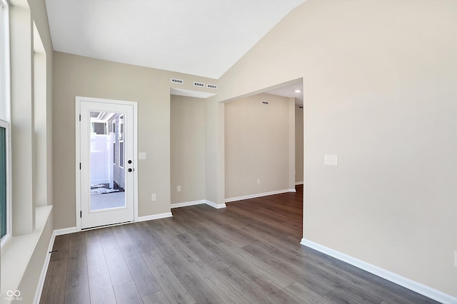 unfurnished room featuring lofted ceiling and wood-type flooring