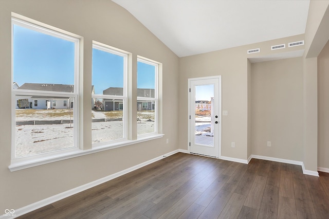 spare room with dark wood-type flooring and vaulted ceiling