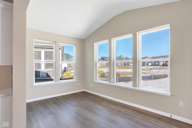 spare room featuring hardwood / wood-style flooring and vaulted ceiling