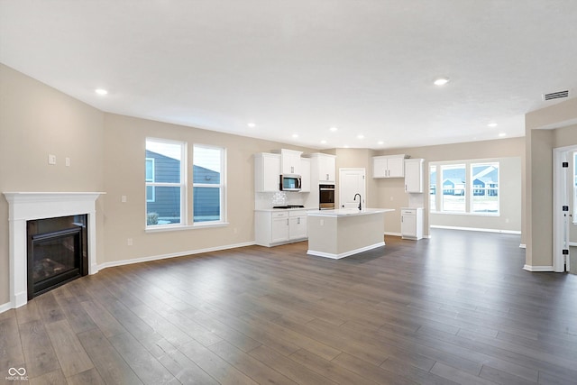 unfurnished living room featuring dark hardwood / wood-style floors and sink