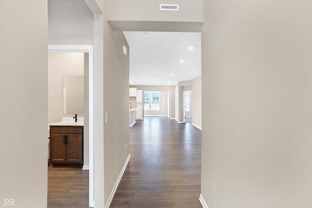 hallway featuring sink and hardwood / wood-style floors