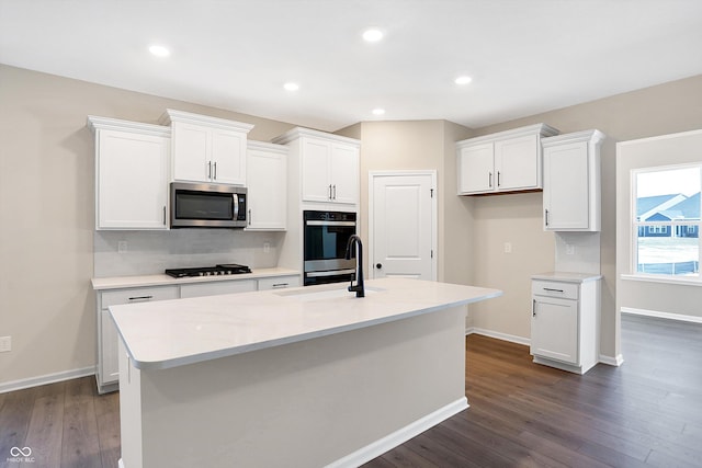 kitchen with black appliances, an island with sink, and white cabinets