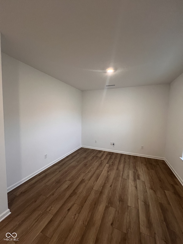 unfurnished room with dark hardwood / wood-style flooring