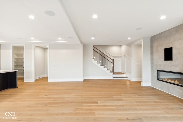 unfurnished living room featuring a fireplace and light hardwood / wood-style flooring