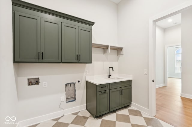 laundry area with electric dryer hookup, cabinets, sink, hookup for a washing machine, and light hardwood / wood-style floors