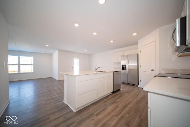 kitchen featuring white cabinets, a center island with sink, stainless steel appliances, dark wood-type flooring, and sink