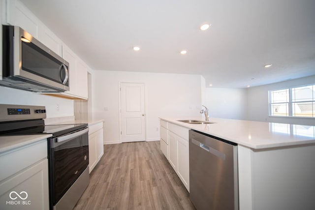 kitchen with white cabinetry, appliances with stainless steel finishes, light countertops, and a sink