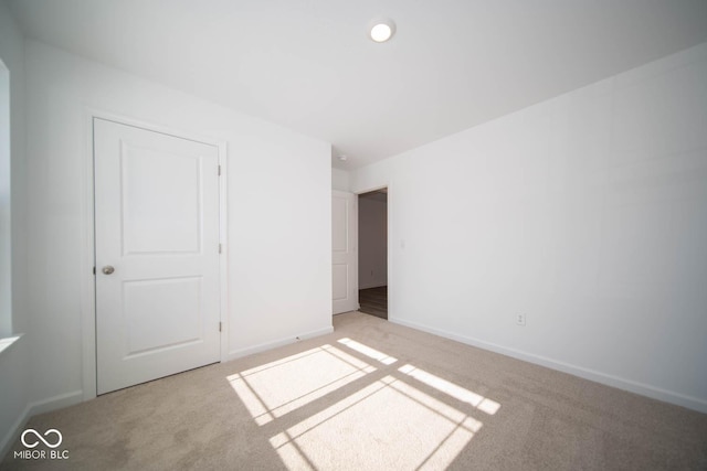 unfurnished bedroom with a closet and light carpet