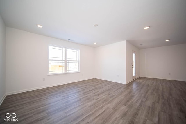 spare room with dark wood-style floors, baseboards, and recessed lighting