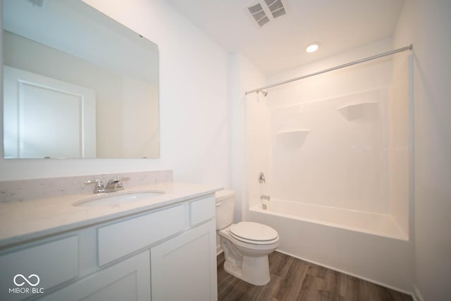 full bath with bathtub / shower combination, visible vents, toilet, vanity, and wood finished floors