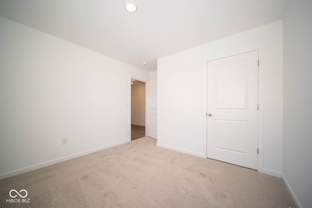 unfurnished bedroom featuring light colored carpet and baseboards