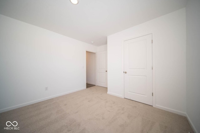 unfurnished bedroom featuring light colored carpet and baseboards