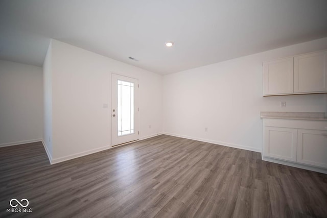 unfurnished living room with dark wood-type flooring, recessed lighting, visible vents, and baseboards