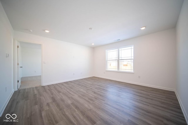 unfurnished room featuring visible vents, baseboards, dark wood-style flooring, and recessed lighting