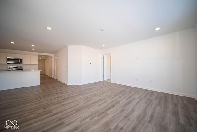 unfurnished living room featuring light wood-style floors, baseboards, and recessed lighting