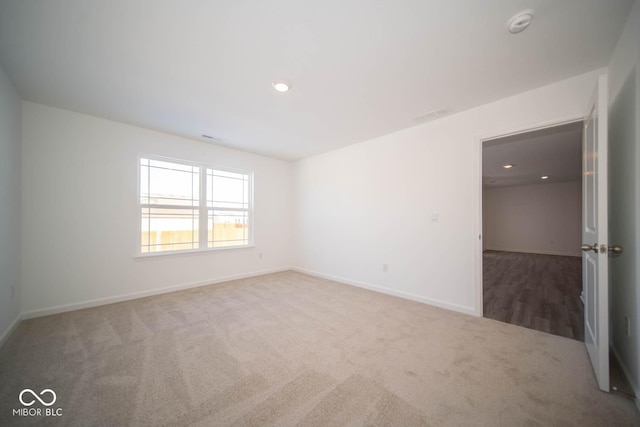 carpeted spare room featuring recessed lighting and baseboards