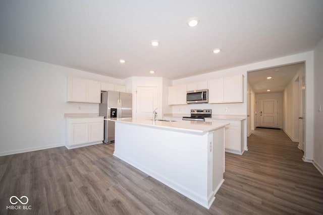 kitchen with a kitchen island with sink, appliances with stainless steel finishes, light hardwood / wood-style floors, sink, and white cabinetry