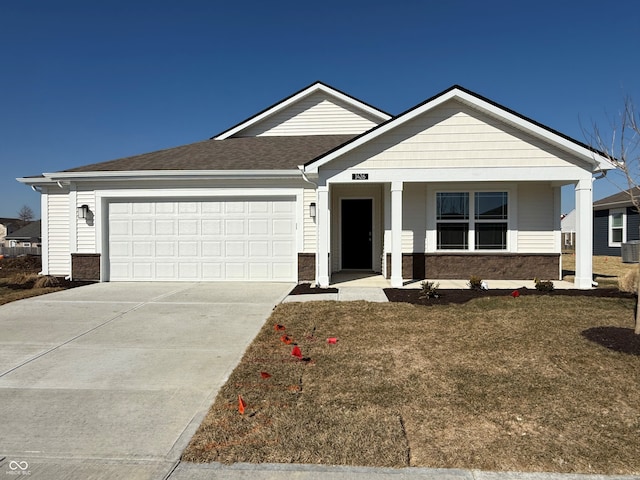 view of front of house featuring driveway, a garage, stone siding, a porch, and a front lawn