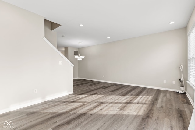 unfurnished living room featuring hardwood / wood-style floors and a chandelier