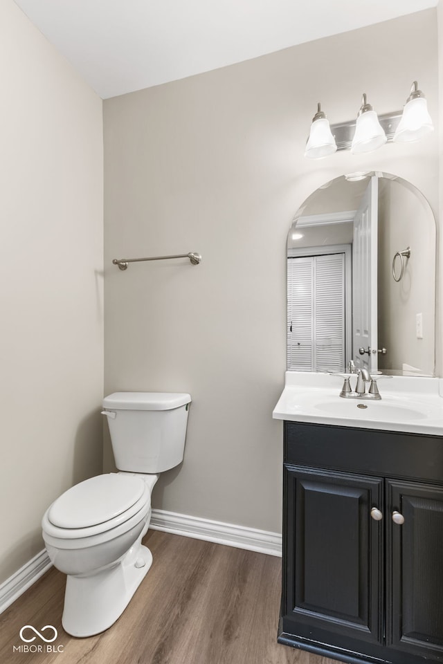 bathroom with vanity, wood-type flooring, and toilet